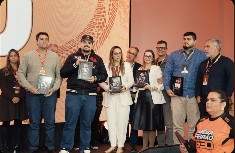 Lojistas premiados com o troféu 100 Carros no palco do evento